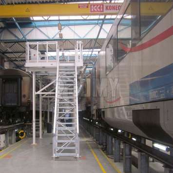 Aluminium toegangstrappen en bordes voor treincabines Toegangsplatform en trappen voor het werken aan de bovenkanten van treincabines in een werkplaats.